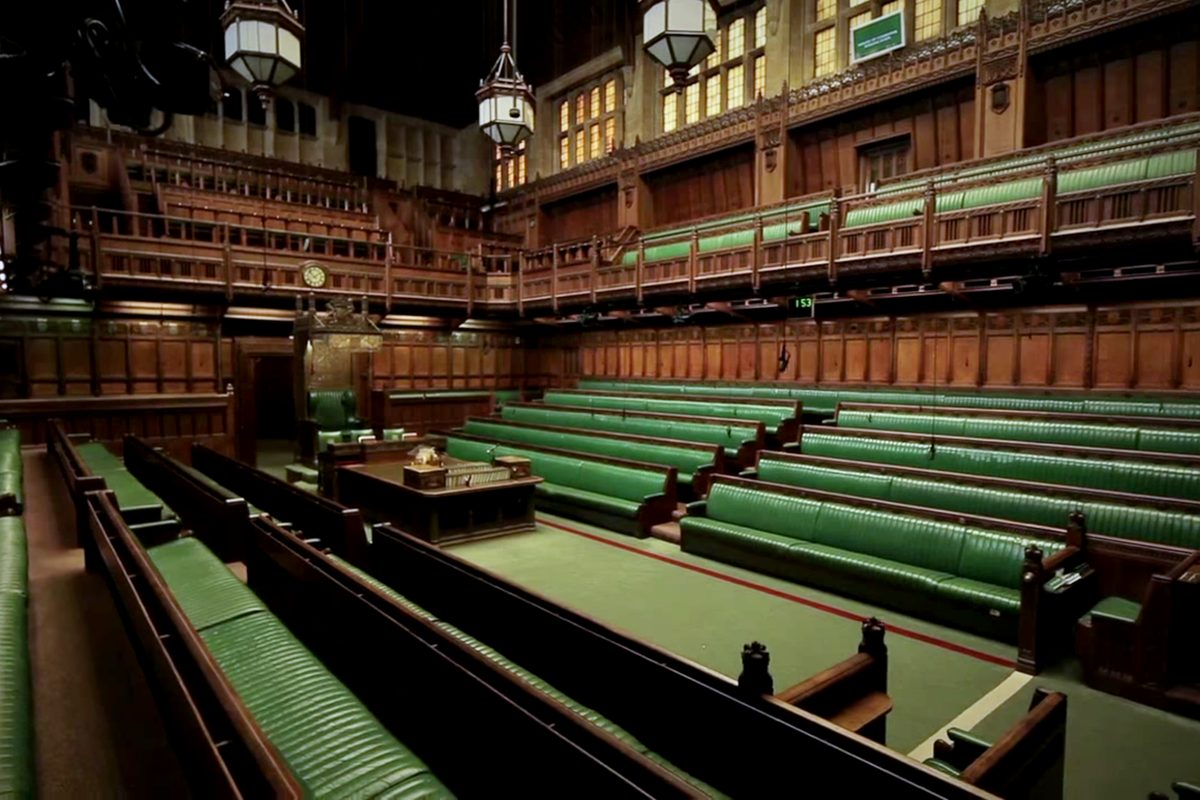 The empty House of Commons chamber, with rows of green leather benches facing each other across the floor